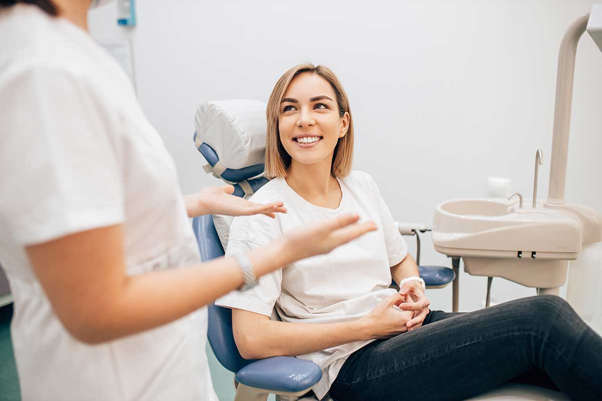 smiling woman talking to dentist in Valencia CA