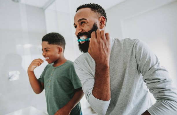 father and son brushing teeth